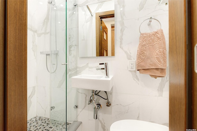 bathroom featuring sink, toilet, tile walls, and walk in shower