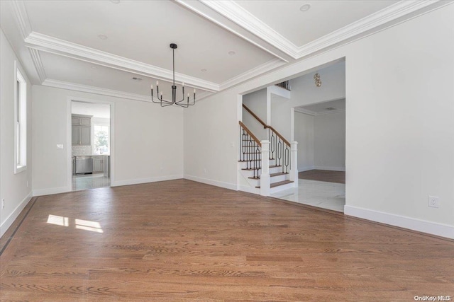 unfurnished dining area with crown molding, a notable chandelier, and hardwood / wood-style flooring