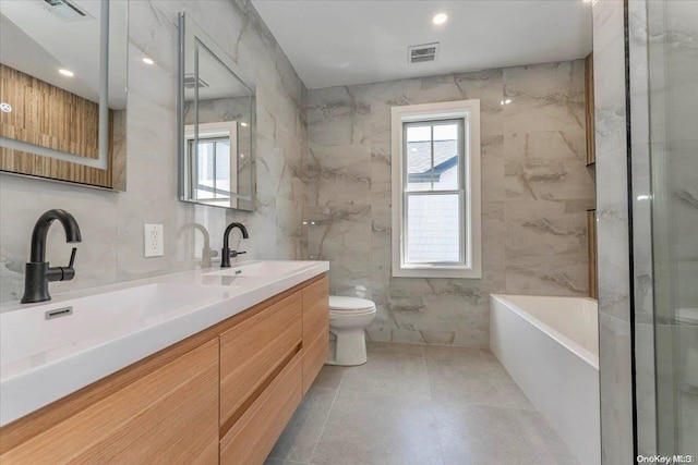 full bathroom featuring vanity, toilet, tile walls, and independent shower and bath