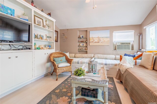 living room featuring light wood-type flooring, vaulted ceiling, and cooling unit