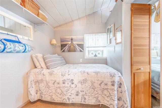 carpeted bedroom featuring wooden ceiling and vaulted ceiling