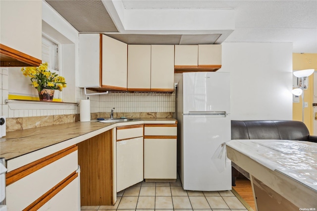 kitchen featuring tasteful backsplash, sink, white cabinets, and white refrigerator