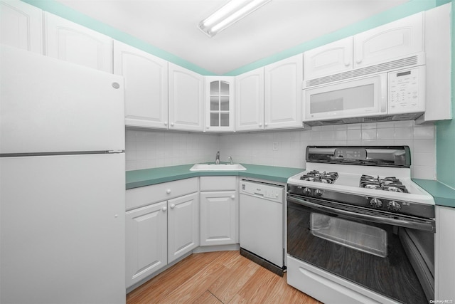 kitchen featuring white cabinetry, sink, tasteful backsplash, light hardwood / wood-style flooring, and white appliances