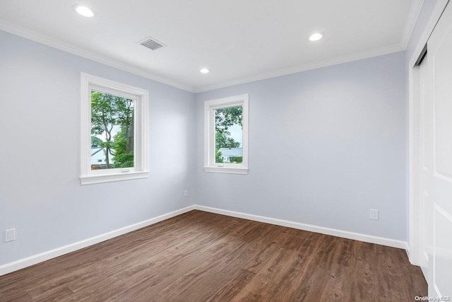 empty room with plenty of natural light, dark wood-type flooring, and ornamental molding