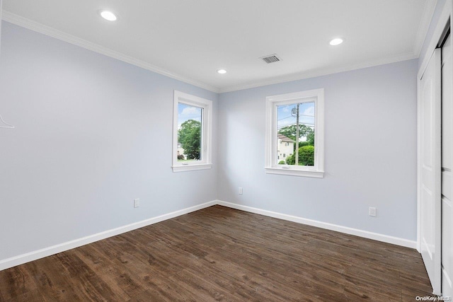 spare room featuring ornamental molding, plenty of natural light, and dark wood-type flooring