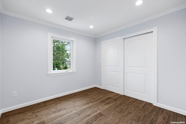 unfurnished bedroom featuring wood-type flooring, a closet, and ornamental molding