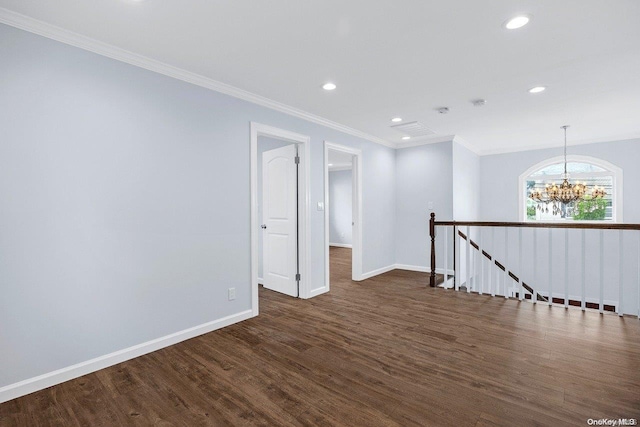 unfurnished room featuring dark hardwood / wood-style flooring, ornamental molding, and a chandelier