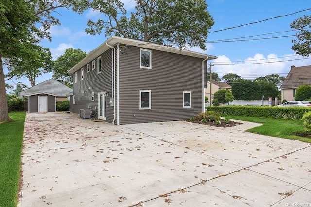 view of property exterior with central AC unit, a storage shed, and a lawn