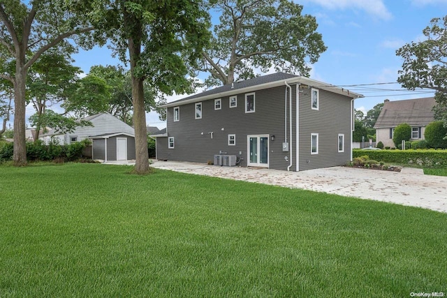 rear view of property featuring a storage shed, a yard, and central air condition unit