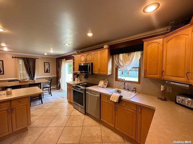 kitchen featuring crown molding, sink, light tile patterned floors, and appliances with stainless steel finishes