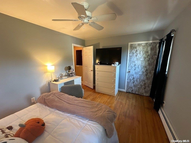 bedroom featuring ceiling fan, wood-type flooring, and baseboard heating