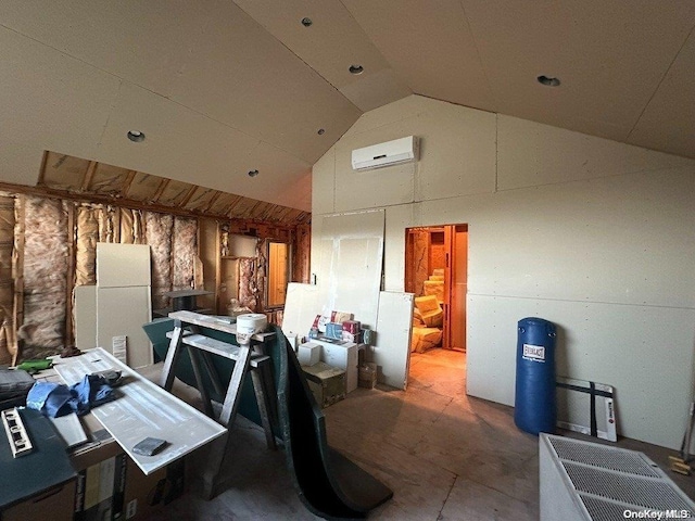 misc room with a wall mounted air conditioner and vaulted ceiling