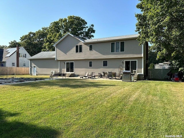 back of house with a yard and a patio