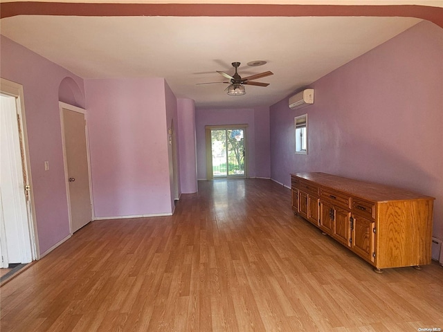 interior space with an AC wall unit, ceiling fan, and light hardwood / wood-style floors