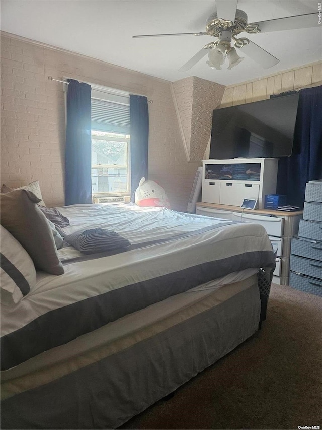 carpeted bedroom with ceiling fan and brick wall