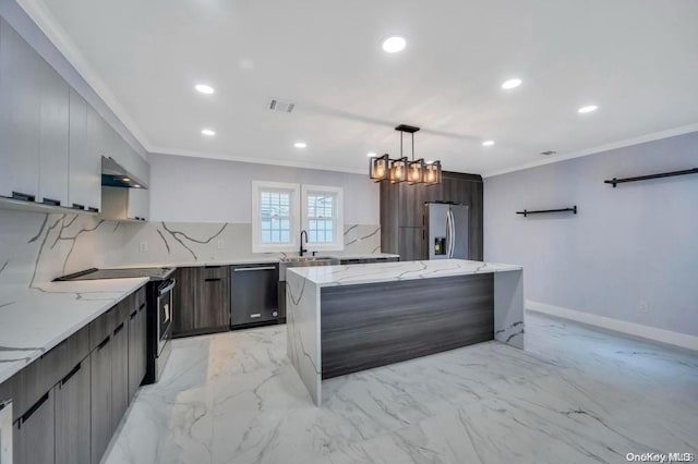 kitchen featuring light stone countertops, appliances with stainless steel finishes, wall chimney exhaust hood, decorative light fixtures, and a notable chandelier