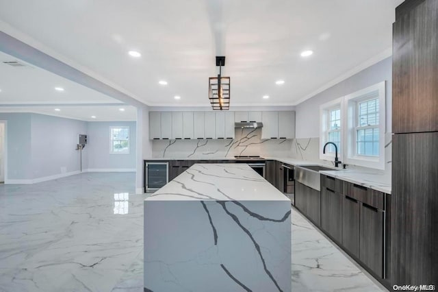 kitchen with a wealth of natural light, sink, a kitchen island, and pendant lighting