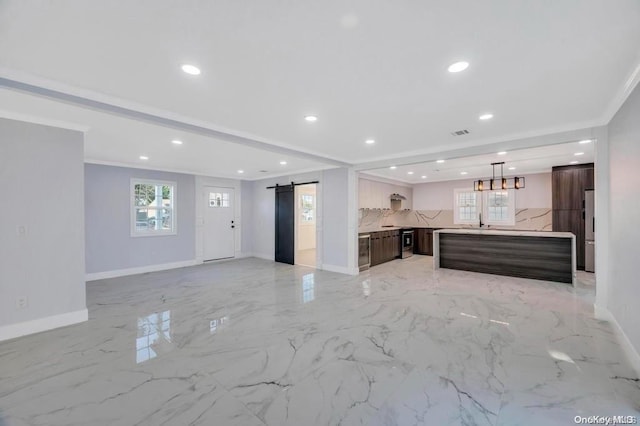 kitchen with sink, a barn door, crown molding, and backsplash