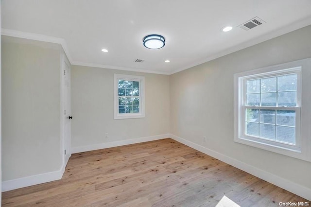 empty room featuring light hardwood / wood-style flooring and crown molding