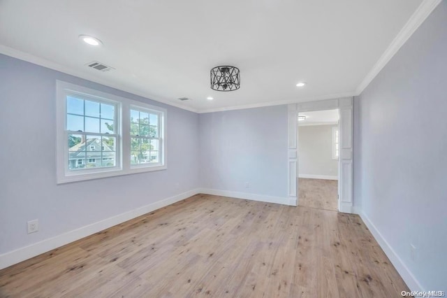 empty room featuring crown molding and light wood-type flooring