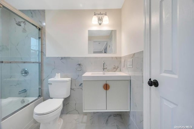 full bathroom featuring vanity, toilet, enclosed tub / shower combo, and tile walls