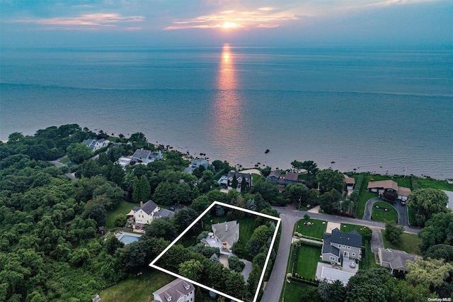 aerial view at dusk featuring a water view