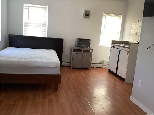 bedroom featuring wood-type flooring and baseboard heating