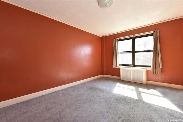 carpeted empty room featuring radiator heating unit, ornamental molding, and vaulted ceiling