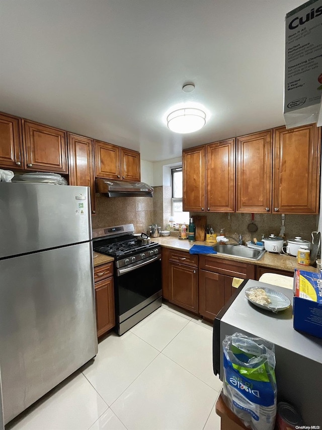 kitchen featuring decorative backsplash, sink, light tile patterned floors, and stainless steel appliances