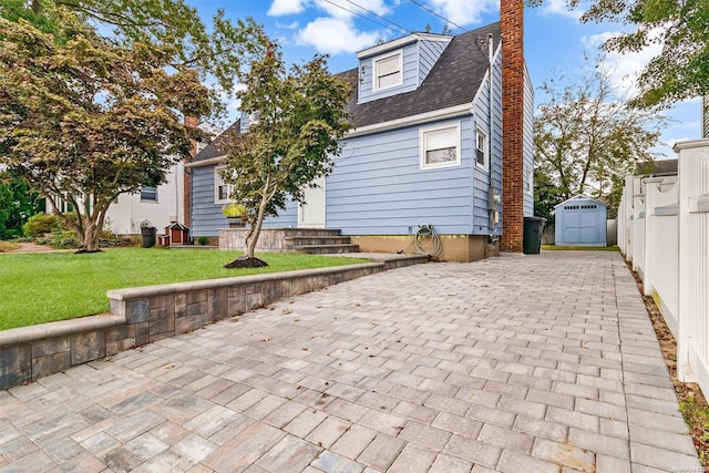 view of front of house with a front lawn and a shed