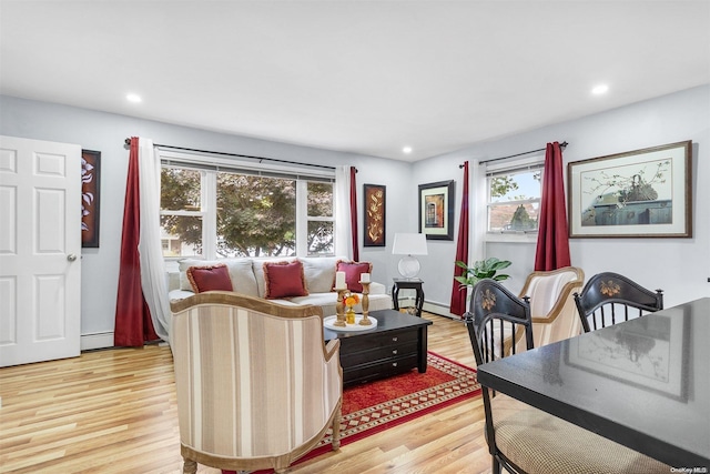 living room with light wood-type flooring and a baseboard heating unit