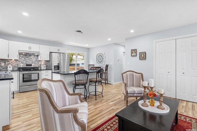 living room with light wood-type flooring and a baseboard heating unit