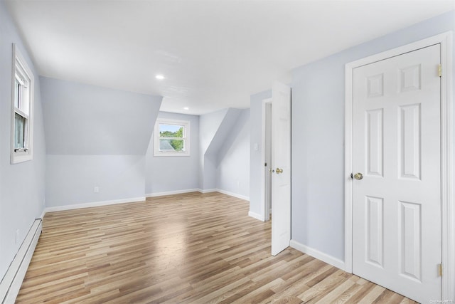 bonus room with light hardwood / wood-style flooring and a baseboard heating unit