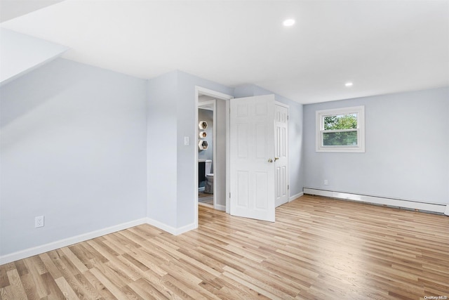 bonus room with light hardwood / wood-style floors and a baseboard heating unit