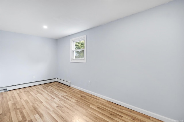 unfurnished room with light hardwood / wood-style floors and a baseboard heating unit