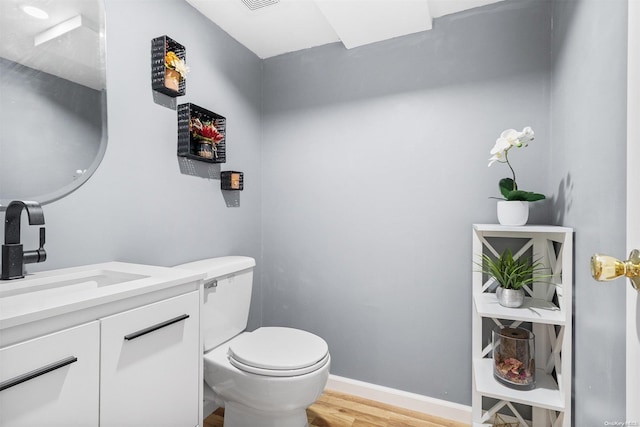 bathroom featuring vanity, hardwood / wood-style flooring, and toilet