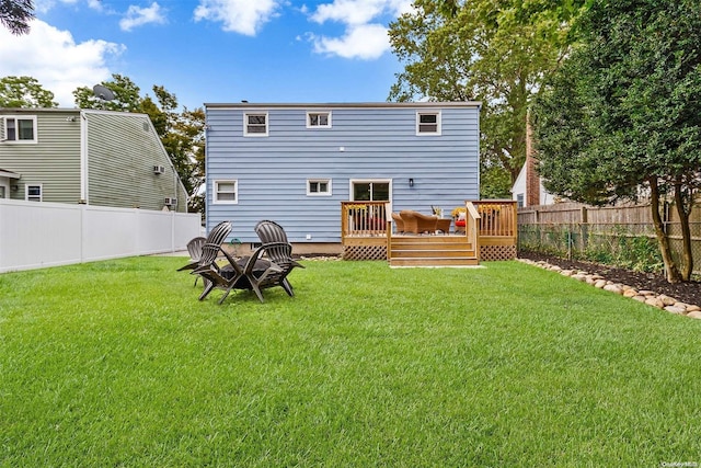 rear view of property with a deck and a yard