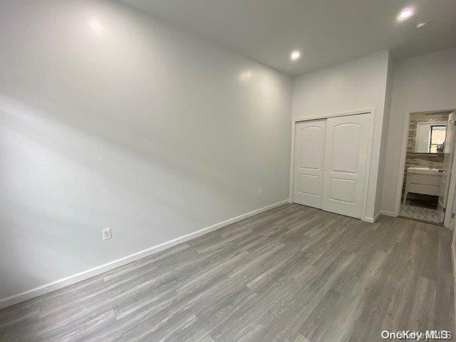 unfurnished bedroom featuring hardwood / wood-style floors and a closet