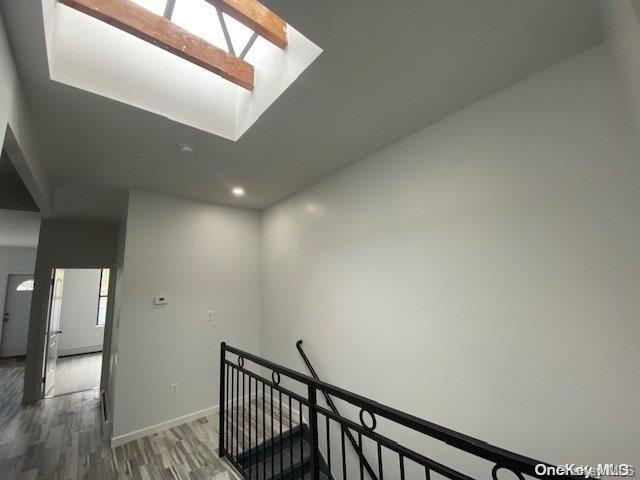 corridor featuring dark hardwood / wood-style flooring and a skylight