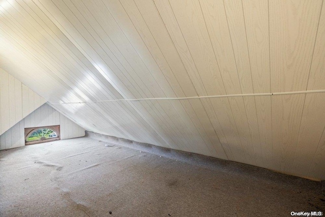 additional living space featuring carpet, wooden ceiling, lofted ceiling, and wood walls