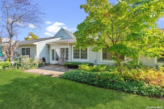 back of property with a patio and a lawn