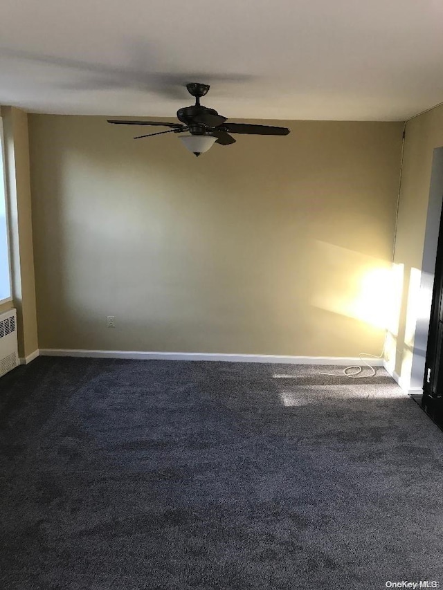 unfurnished room with dark carpet and ceiling fan