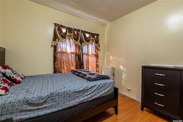 bedroom featuring light hardwood / wood-style floors and radiator heating unit