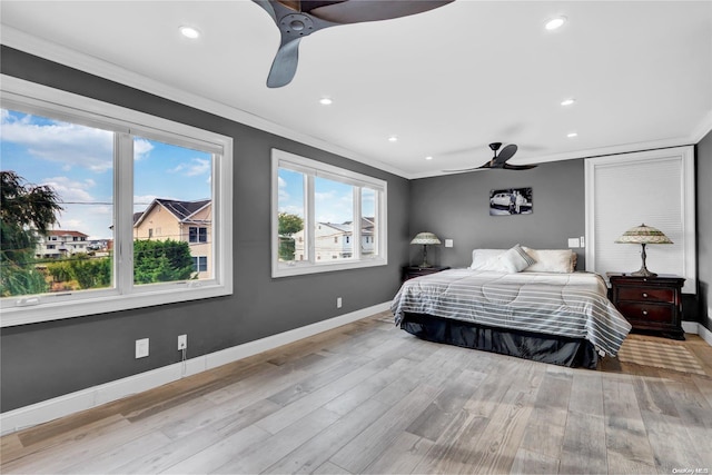 bedroom featuring ceiling fan, light hardwood / wood-style floors, and ornamental molding