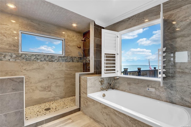 bathroom featuring a water view, plenty of natural light, and independent shower and bath