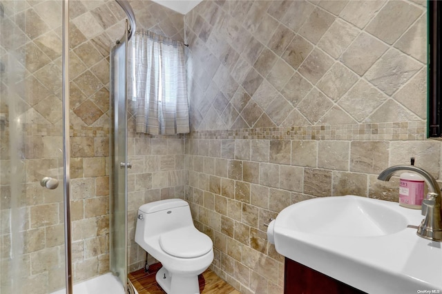 bathroom with an enclosed shower, vanity, toilet, and wood-type flooring