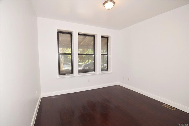 spare room with dark wood-type flooring