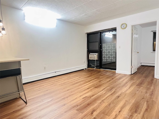 interior space featuring cooling unit, light wood-type flooring, and a baseboard radiator