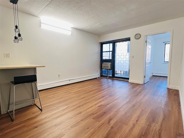 spare room featuring a baseboard radiator and hardwood / wood-style floors