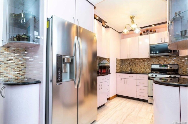 kitchen with appliances with stainless steel finishes, tasteful backsplash, sink, a chandelier, and white cabinetry